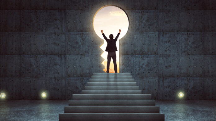 Success,Businessman,Cheering,On,Stair,Against,Concrete,Wall,With,Key